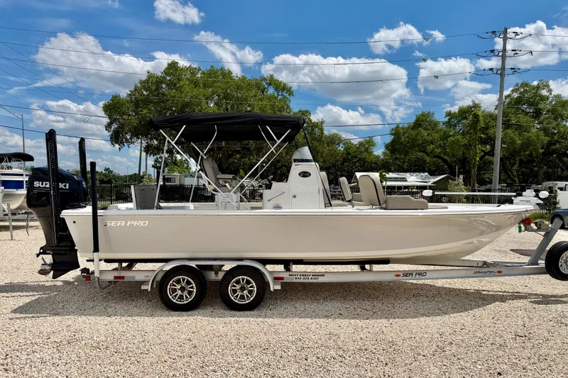 Slide: The Image of 2022 Sea Pro 248 Bay boat on trailer, under clear blue sky. - 4