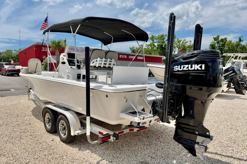 Slide: The Image of 2022 Sea Pro 248 Bay boat with Suzuki engine on trailer, parked outdoors. - 7
