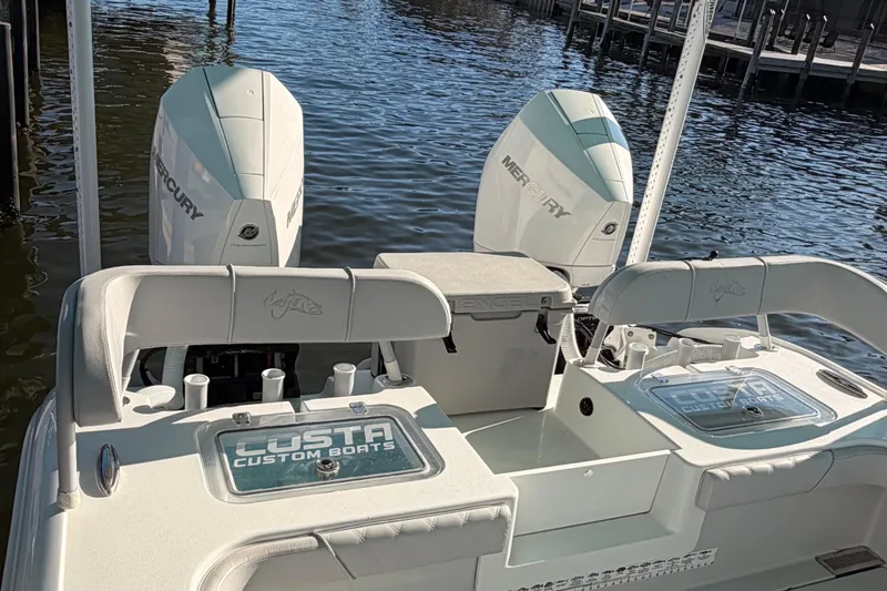 Slide: The Image of 2020 Costa Custom Boats 264 HC with dual Mercury engines docked by the water. - 12
