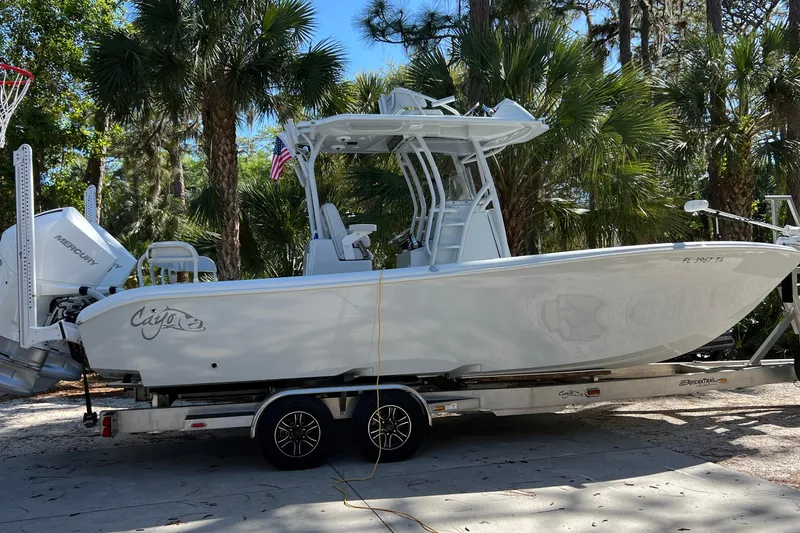 Slide: The Image of 2020 Costa Custom Boats 264 HC on trailer, surrounded by palm trees. - 2