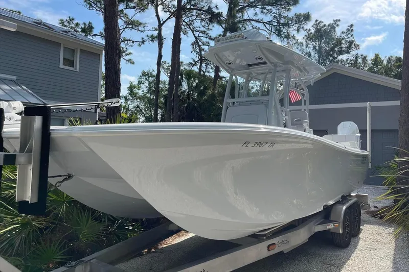 Slide: The Image of 2020 Costa Custom Boats 264 HC on trailer, parked near a house with trees. - 3