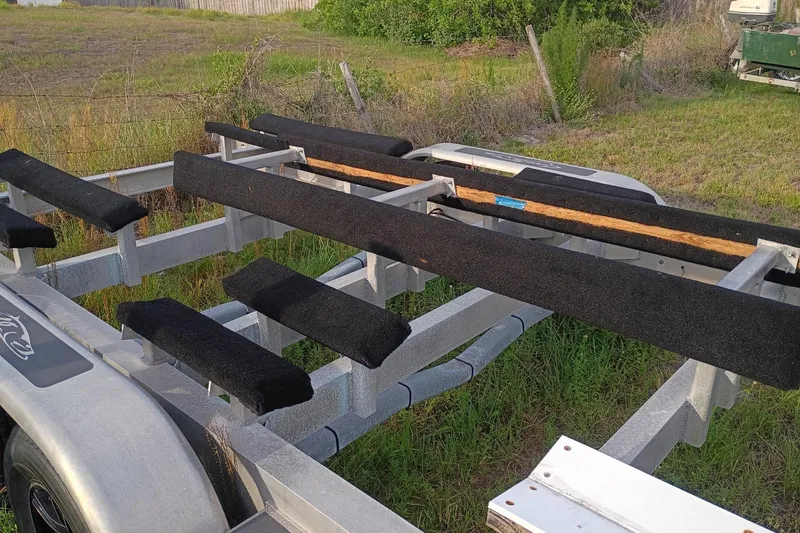 Slide: The Image of Boat trailer for 2020 Costa Custom Boats 264HC, parked on grassy area. - 31