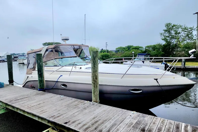 The Image of 2005 Rinker Fiesta Vee 320 docked at a marina, overcast sky in background. - 0