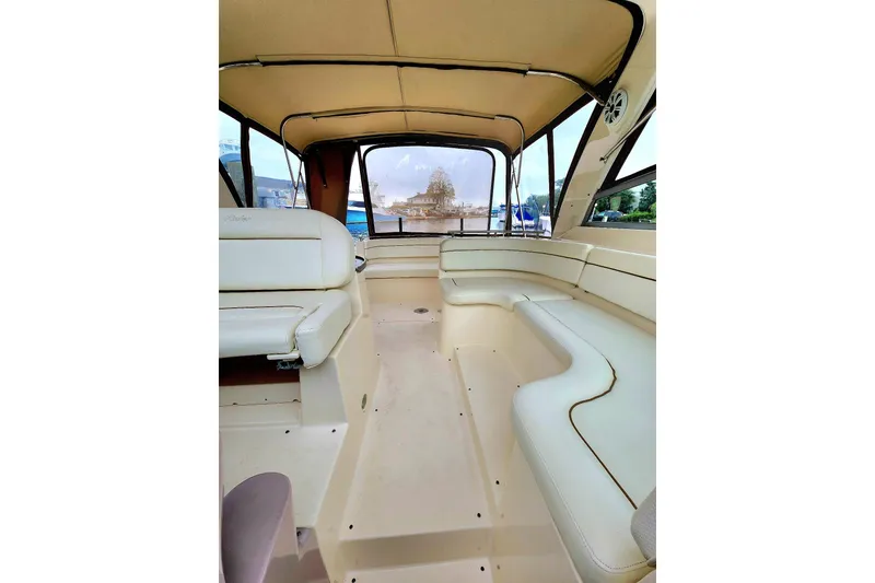 Slide: The Image of 2005 Rinker Fiesta Vee 320 boat interior with beige seating and canopy. - 12