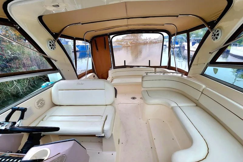 Slide: The Image of Interior view of a 2005 Rinker Fiesta Vee 320 boat with beige seating and windows. - 13