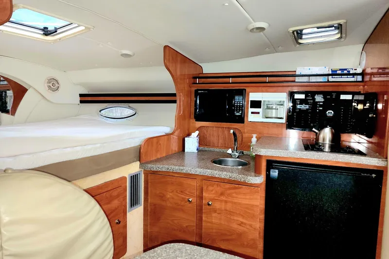 Slide: The Image of 2005 Rinker Fiesta Vee 320 cabin interior with kitchenette and bed. - 4