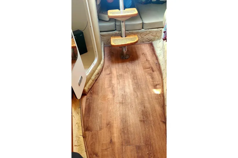 Slide: The Image of 2005 Rinker Fiesta Vee 320 interior with wooden flooring and cushioned seating. - 6