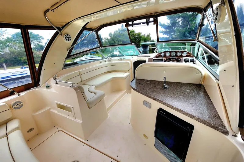 Slide: The Image of 2005 Rinker Fiesta Vee 320 boat interior with seating, helm, and kitchenette area. - 9