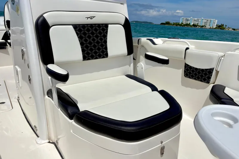 Slide: The Image of 2021 Tidewater 256 CC Adventure boat interior with cushioned seating and ocean view. - 10