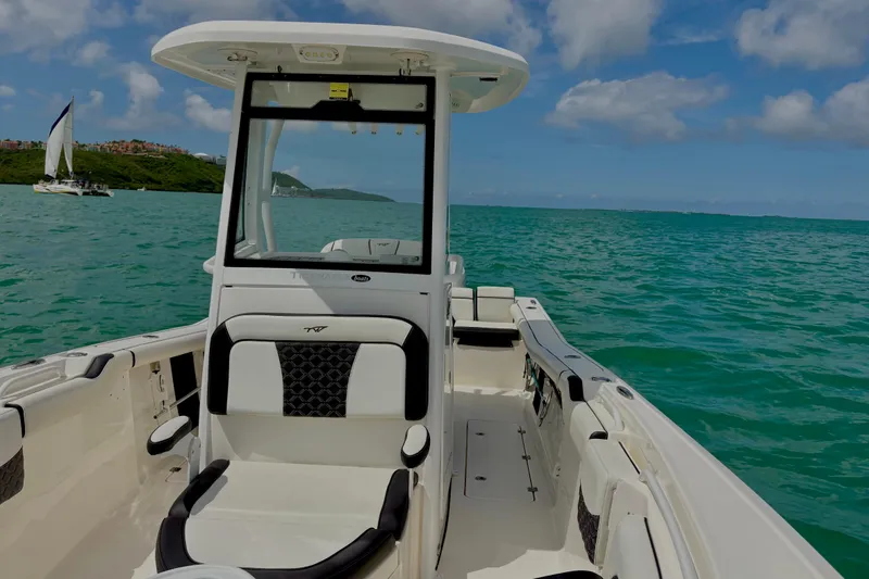 Slide: The Image of 2021 Tidewater 256 CC Adventure boat on turquoise water with sailboat in background. - 16
