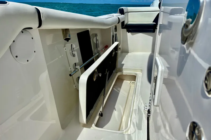 Slide: The Image of 2021 Tidewater 256 CC Adventure boat interior with open storage compartment, ocean view. - 21