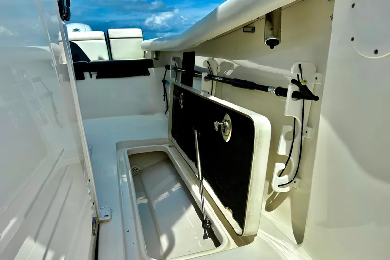 Slide: The Image of 2021 Tidewater 256 CC Adventure boat interior with storage compartment and fishing rod holders. - 22