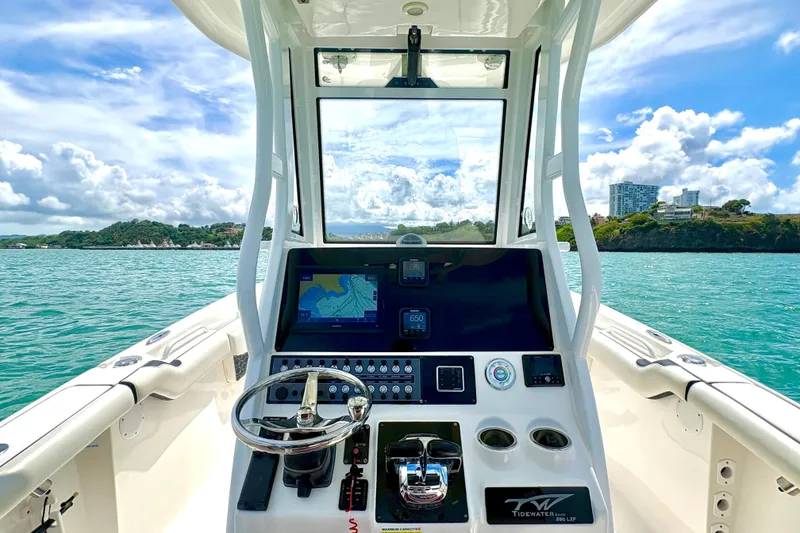 Slide: The Image of 2021 Tidewater 256 CC Adventure boat dashboard with ocean view and modern controls. - 5