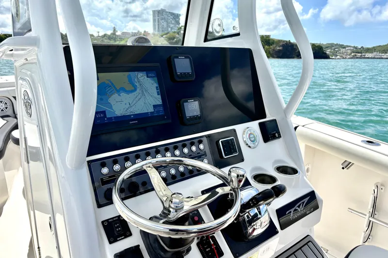 Slide: The Image of 2021 Tidewater 256 CC Adventure boat dashboard with navigation system and steering wheel. - 6