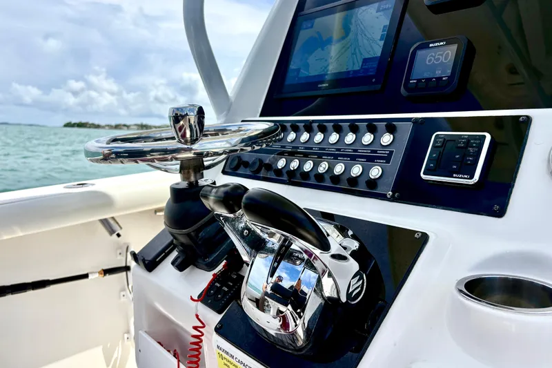 Slide: The Image of Control panel of a 2021 Tidewater 256 CC Adventure boat with steering wheel and navigation system. - 7