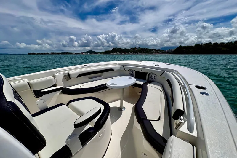 Slide: The Image of 2021 Tidewater 256 CC Adventure boat interior with seating and table on open water. - 9