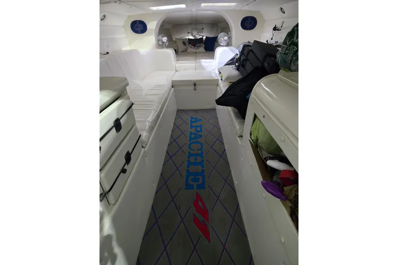 Slide: The Image of Interior of 1989 Apache 41 "The Chief" boat with white seating and storage compartments. - 4