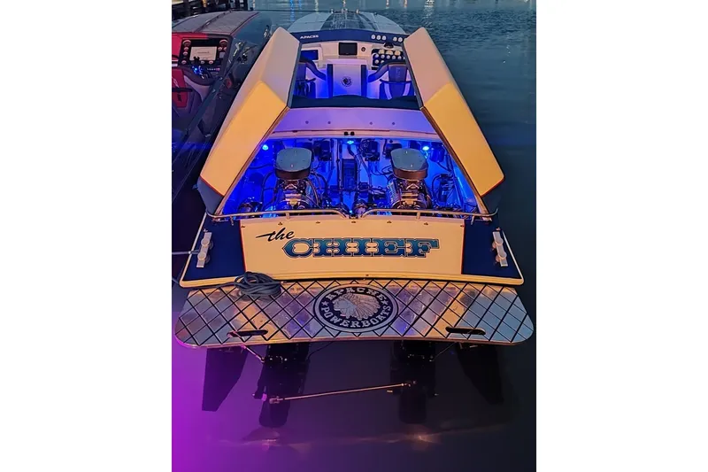Slide: The Image of 1989 Apache 41 "The Chief" powerboat with illuminated engine bay at dusk. - 5