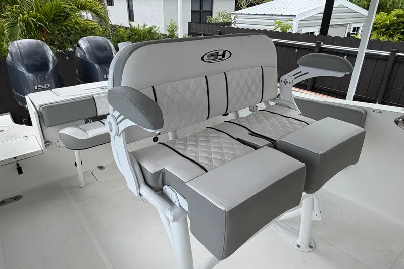 Slide: The Image of 2016 Sea Hunt Gamefish 25 boat interior with cushioned seating and dual outboard motors. - 12