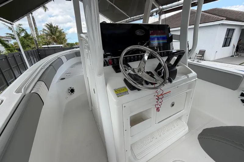 Slide: The Image of 2016 Sea Hunt Gamefish 25 boat interior with steering wheel and control panel. - 22