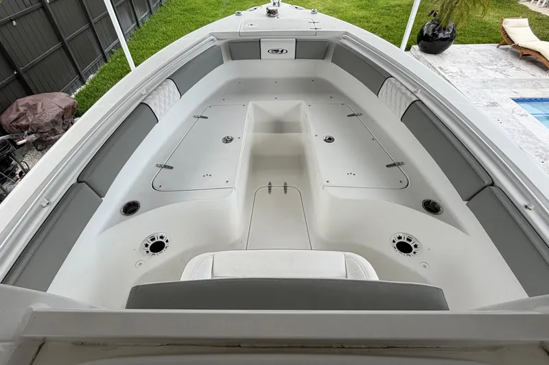 Slide: The Image of 2016 Sea Hunt Gamefish 25 boat interior with spacious seating and storage compartments. - 26