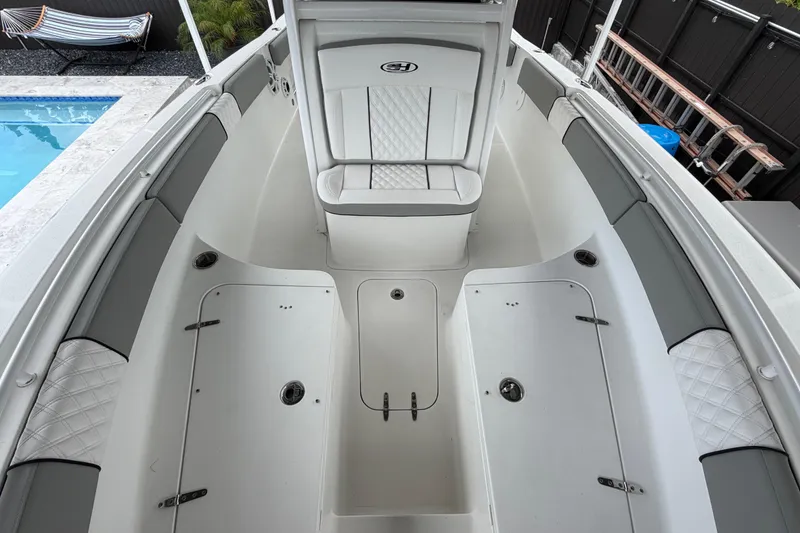 Slide: The Image of 2016 Sea Hunt Gamefish 25 boat interior with cushioned seating and storage compartments. - 28