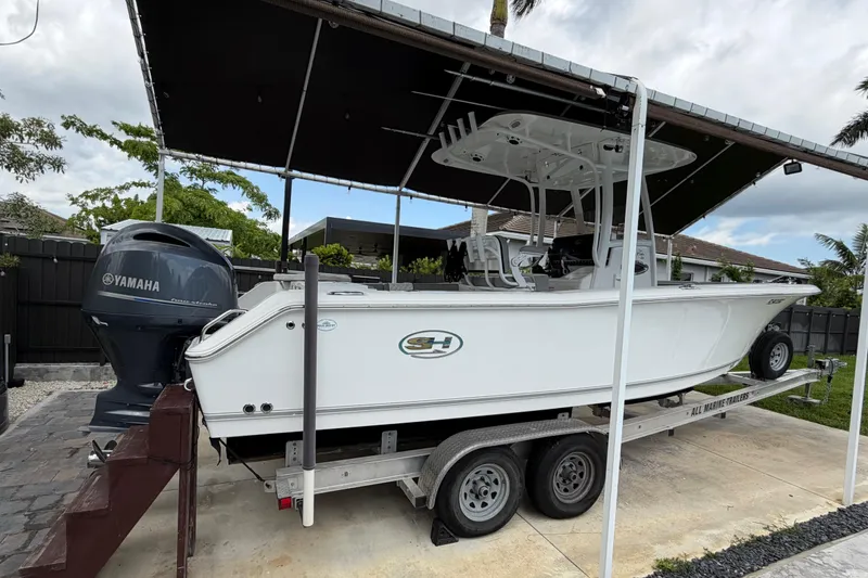 Slide: The Image of 2016 Sea Hunt Gamefish 25 boat on trailer with Yamaha engine, parked under canopy. - 3