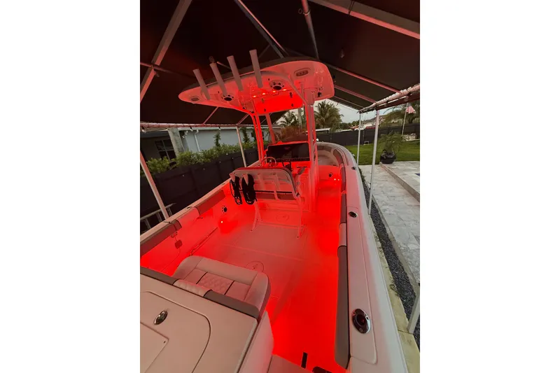 Slide: The Image of 2016 Sea Hunt Gamefish 25 boat with red interior lighting under a canopy. - 39