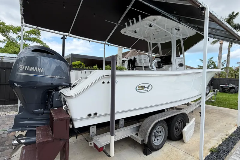 Slide: The Image of 2016 Sea Hunt Gamefish 25 boat on trailer with Yamaha engine, under canopy. - 6
