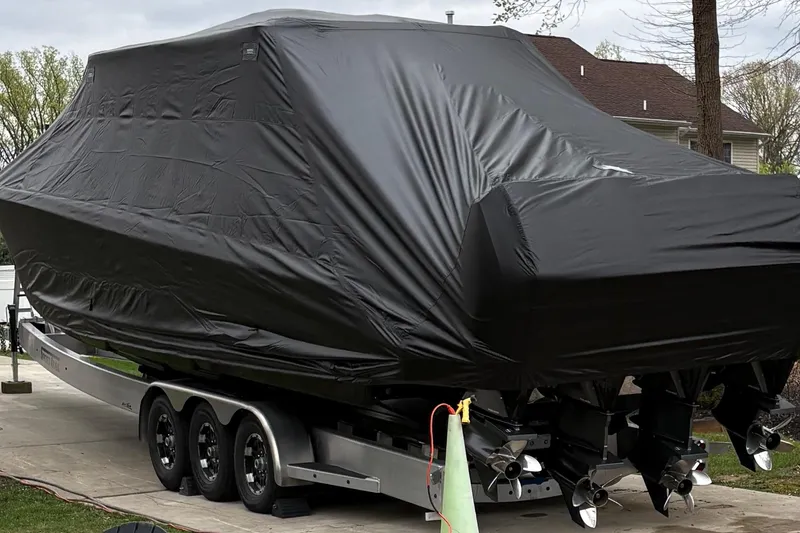 Slide: The Image of Covered 2022 Nor-Tech 390 Sport Center Console boat on trailer in driveway. - 11