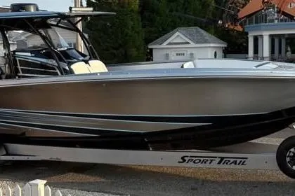 Slide: The Image of 2022 Nor-Tech 390 Sport Center Console boat on trailer, sleek design, outdoor setting. - 4