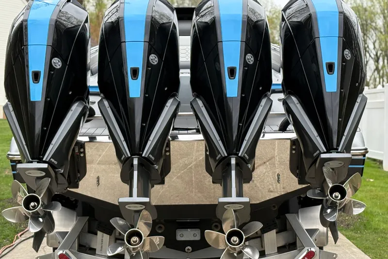 Slide: The Image of Four powerful outboard motors on a 2022 Nor-Tech 390 Sport Center Console boat. - 5