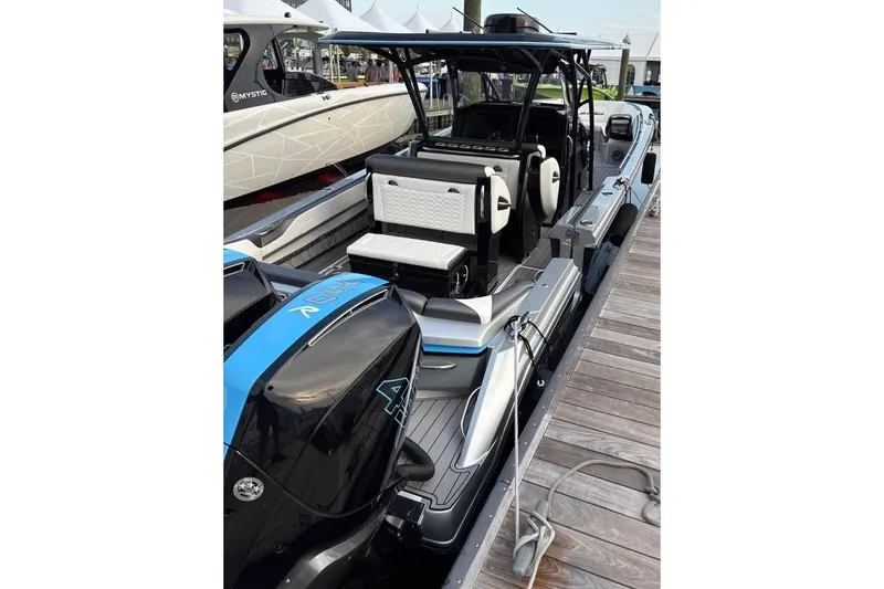 Slide: The Image of 2022 Nor-Tech 390 Sport Center Console boat docked, showcasing sleek design and powerful engines. - 6