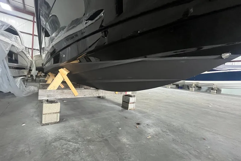 Slide: The Image of 2017 Scout 320 LXF boat hull in storage, supported by wooden blocks. - 10