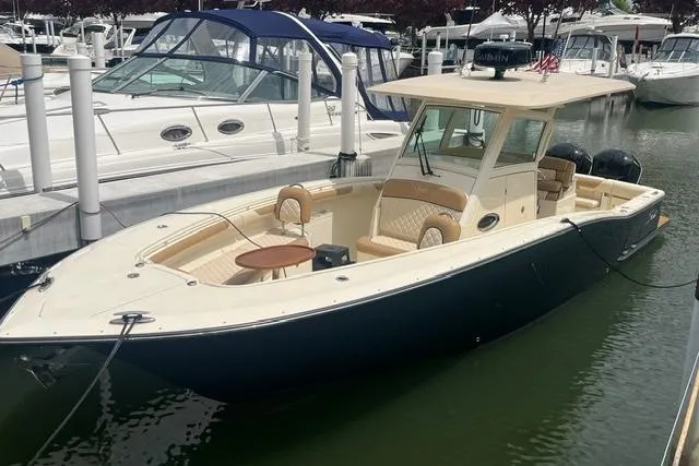 Slide: The Image of 2017 Scout 320 LXF boat docked in marina, featuring sleek design and spacious seating. - 13