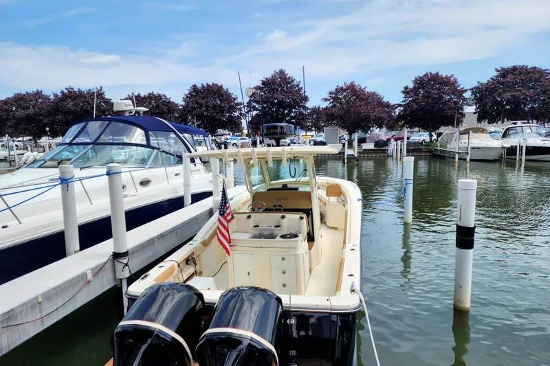 Slide: The Image of 2017 Scout 320 LXF boat docked in marina with American flag. - 14