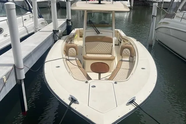 Slide: The Image of 2017 Scout 320 LXF boat docked, featuring elegant seating and sleek design. - 15