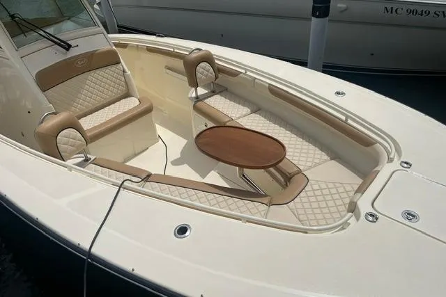 Slide: The Image of 2017 Scout 320 LXF boat with elegant seating and a wooden table on deck. - 16