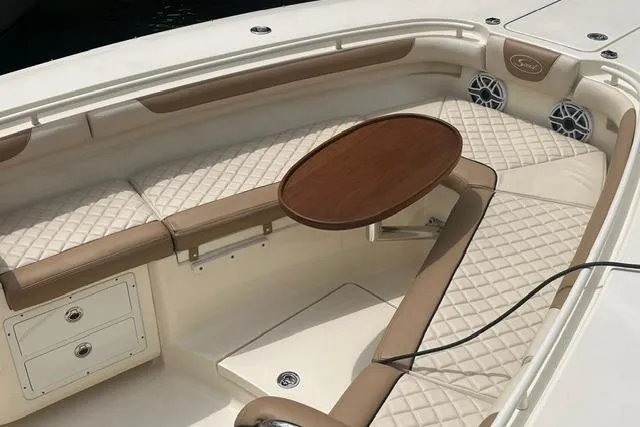Slide: The Image of Luxurious seating area on a 2017 Scout 320 LXF boat with elegant wood table. - 18