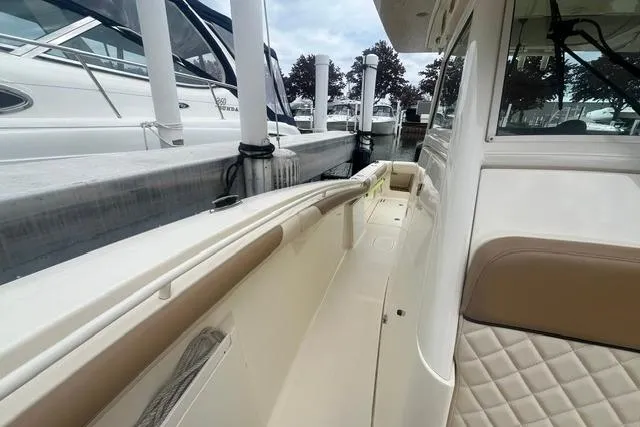 Slide: The Image of 2017 Scout 320 LXF boat docked, featuring sleek design and comfortable seating. - 24