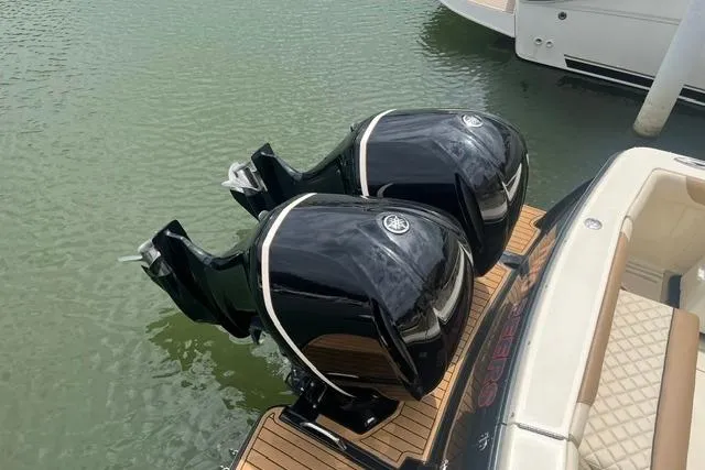 Slide: The Image of 2017 Scout 320 LXF boat with dual outboard engines on water. - 28