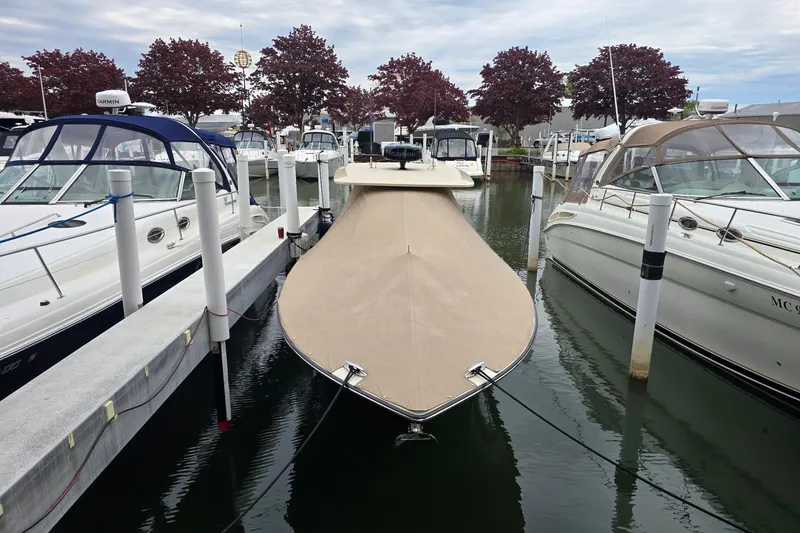 Slide: The Image of 2017 Scout 320 LXF boat docked at marina, covered with beige tarp. - 3
