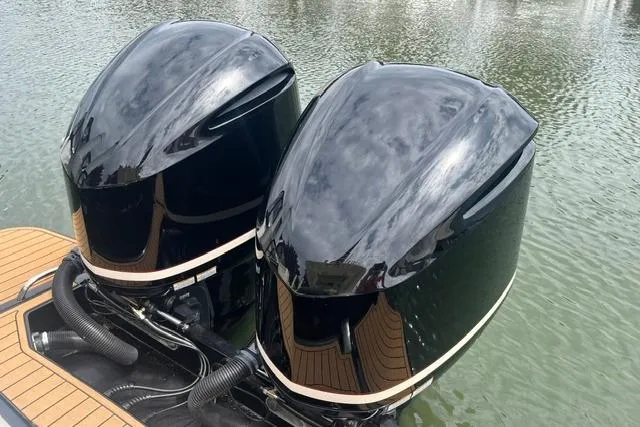 Slide: The Image of Twin outboard engines on a 2017 Scout 320 LXF boat, reflecting on water. - 30