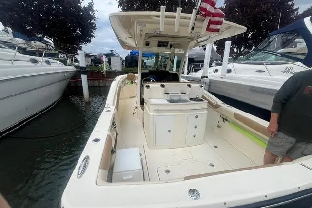 Slide: The Image of 2017 Scout 320 LXF boat docked, featuring spacious deck and modern amenities. - 31
