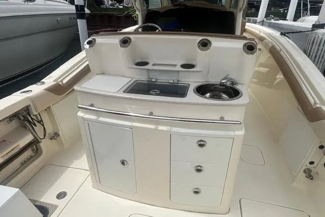 Slide: The Image of 2017 Scout 320 LXF boat interior with sink, storage cabinets, and countertop. - 32