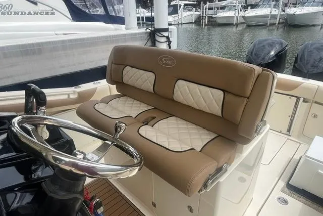 Slide: The Image of 2017 Scout 320 LXF boat interior with luxurious seating and steering wheel at marina. - 33