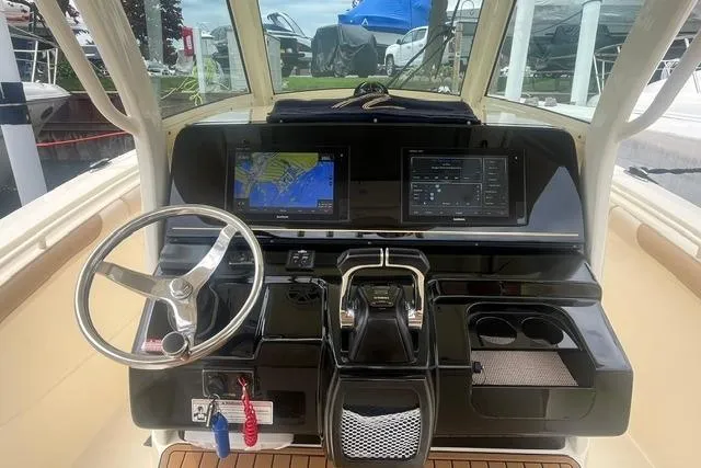 Slide: The Image of 2017 Scout 320 LXF boat dashboard with navigation screens and steering wheel. - 34