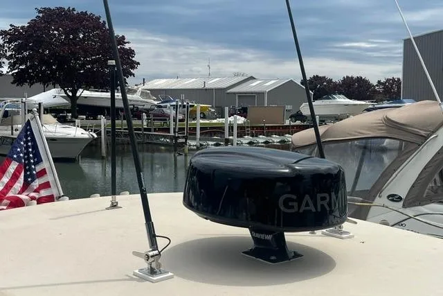 Slide: The Image of 2017 Scout 320 LXF boat with Garmin radar, docked in a marina with American flag. - 46
