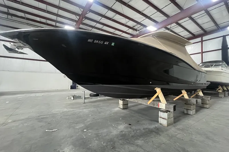 Slide: The Image of 2017 Scout 320 LXF boat in storage, black hull, indoor facility. - 5