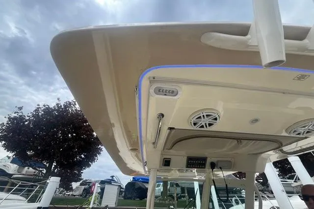 Slide: The Image of 2017 Scout 320 LXF boat canopy with speakers and lighting, docked under cloudy sky. - 57